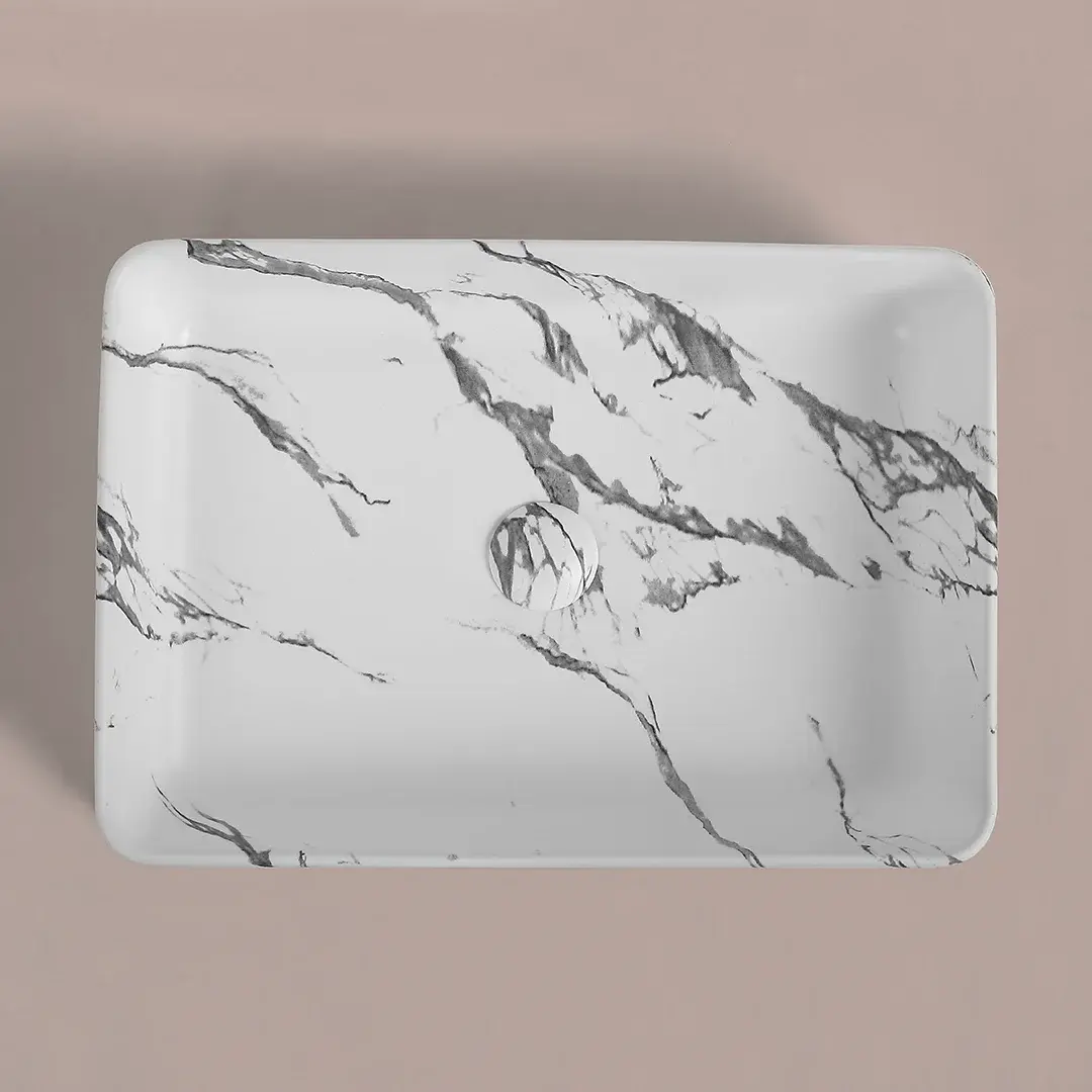 vasque à poser céramique beige, finition effet marbre calacatta, au design rectangulaire épuré avec bonde assortie intégrée.