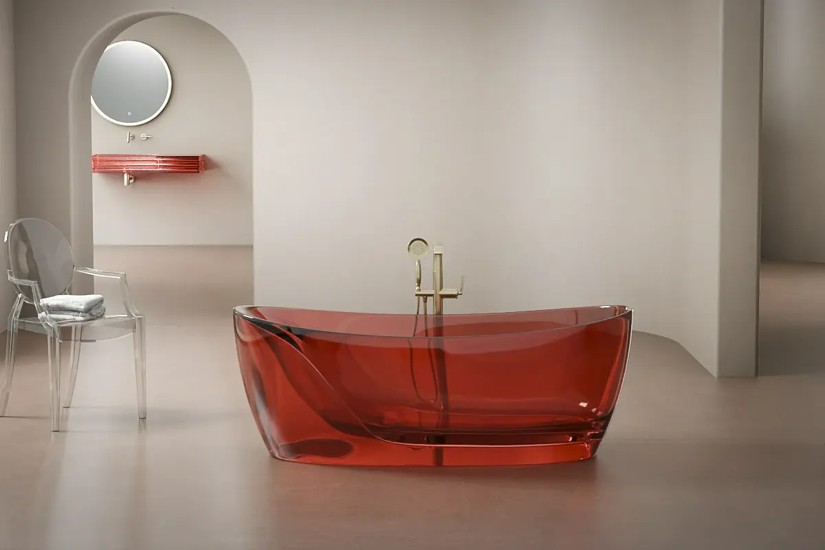 Baignoire rouge translucide en version îlot, forme architecturale avec effet verrier éclatant sous la lumière.