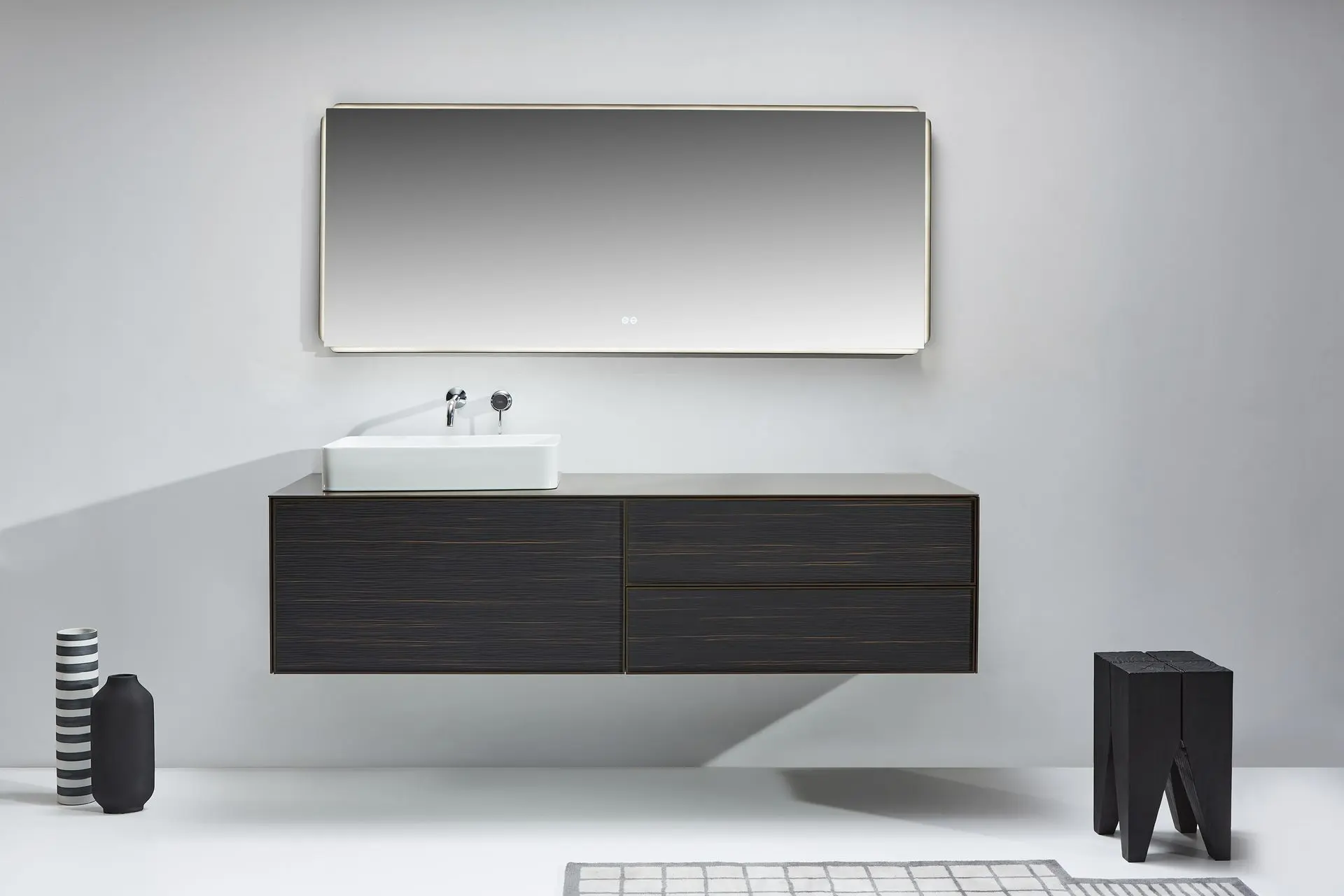 Ensemble de salle de bain moderne composé d’un meuble vasque suspendu en palissandre Rio, surmonté d’un plan en aluminium laqué brun doré. Une vasque à poser en céramique blanche et un large miroir LED rectangulaire complètent l’ensemble, apportant élégance et luminosité à l’espace.