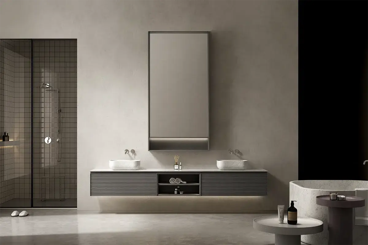 Ensemble majestueux de salle de bain composé d’un meuble cannelé en bois gris de 280x55 cm, surmonté d’un plan en marbre véritable blanc Carrare. Deux vasques à poser en marbre assorti (50x30 cm chacune) offrent une double fonctionnalité dans un équilibre parfait. Le miroir LED 100x200 cm encadré de bois gris prolonge la ligne du meuble dans un style élégant et contemporain.