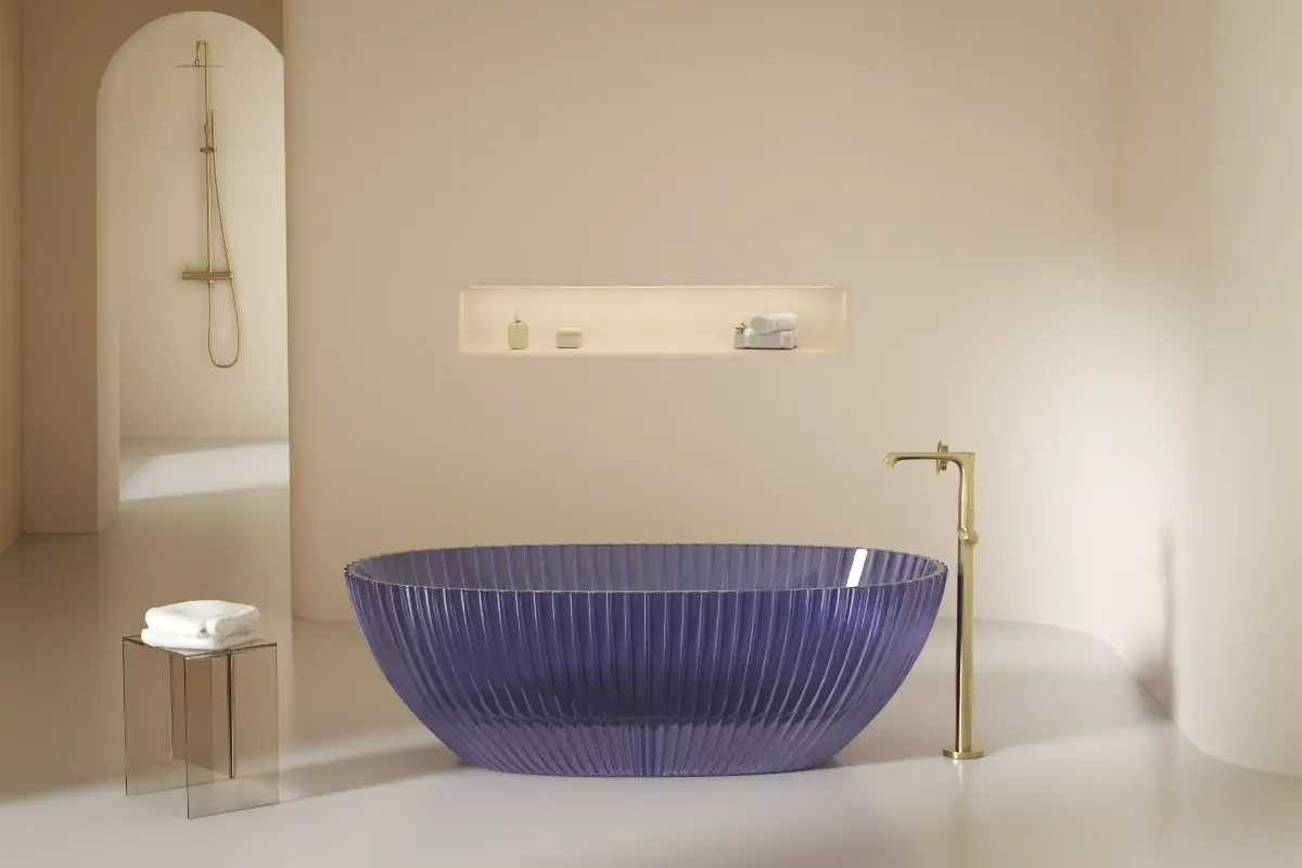 Baignoire îlot ovale en résine transparente violette (Purple), finition cannelée, posée sur un sol clair avec robinetterie sur pied assortie.