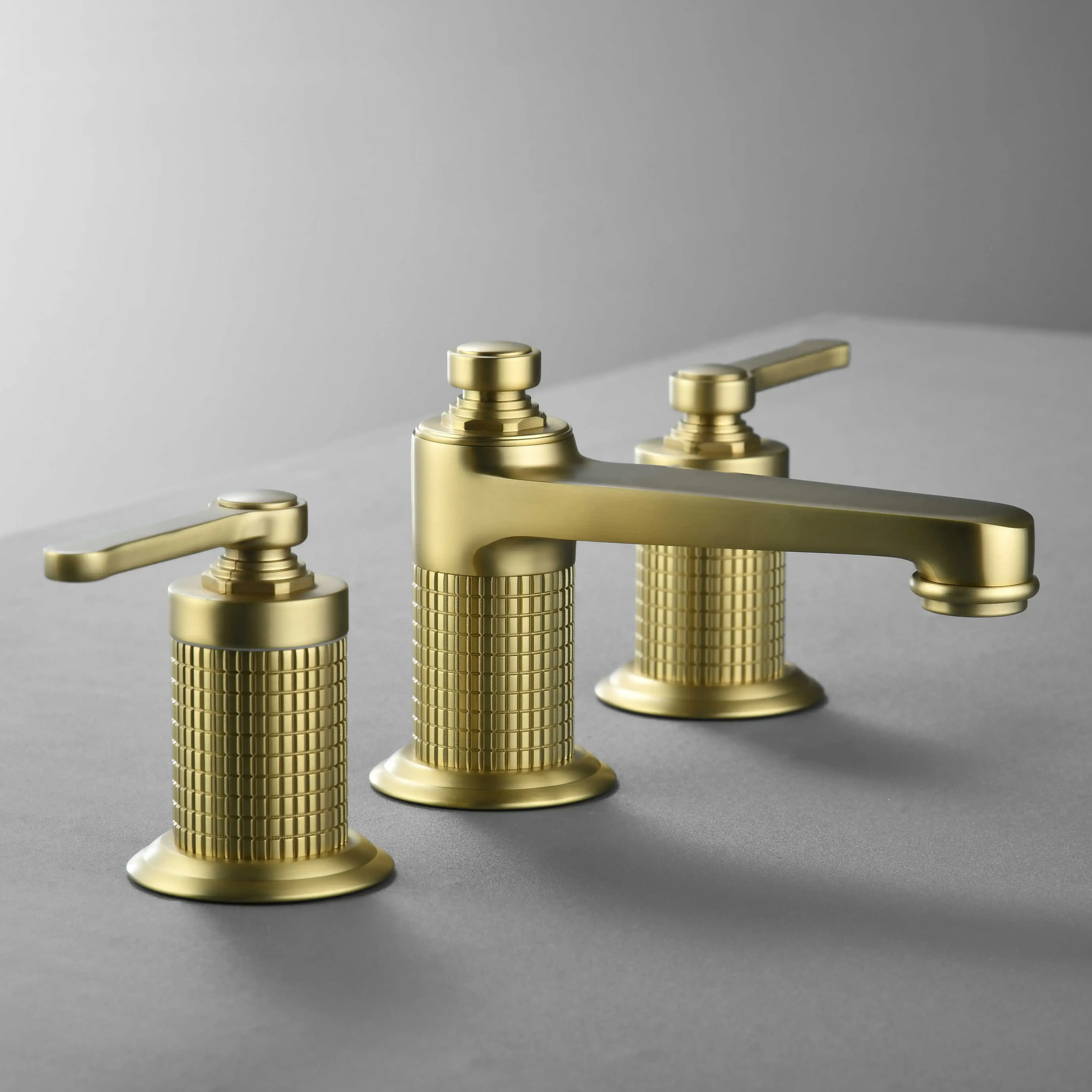 Mélangeur César doré brossé à 3 trous avec poignées guillochées, installation sur plan lavabo