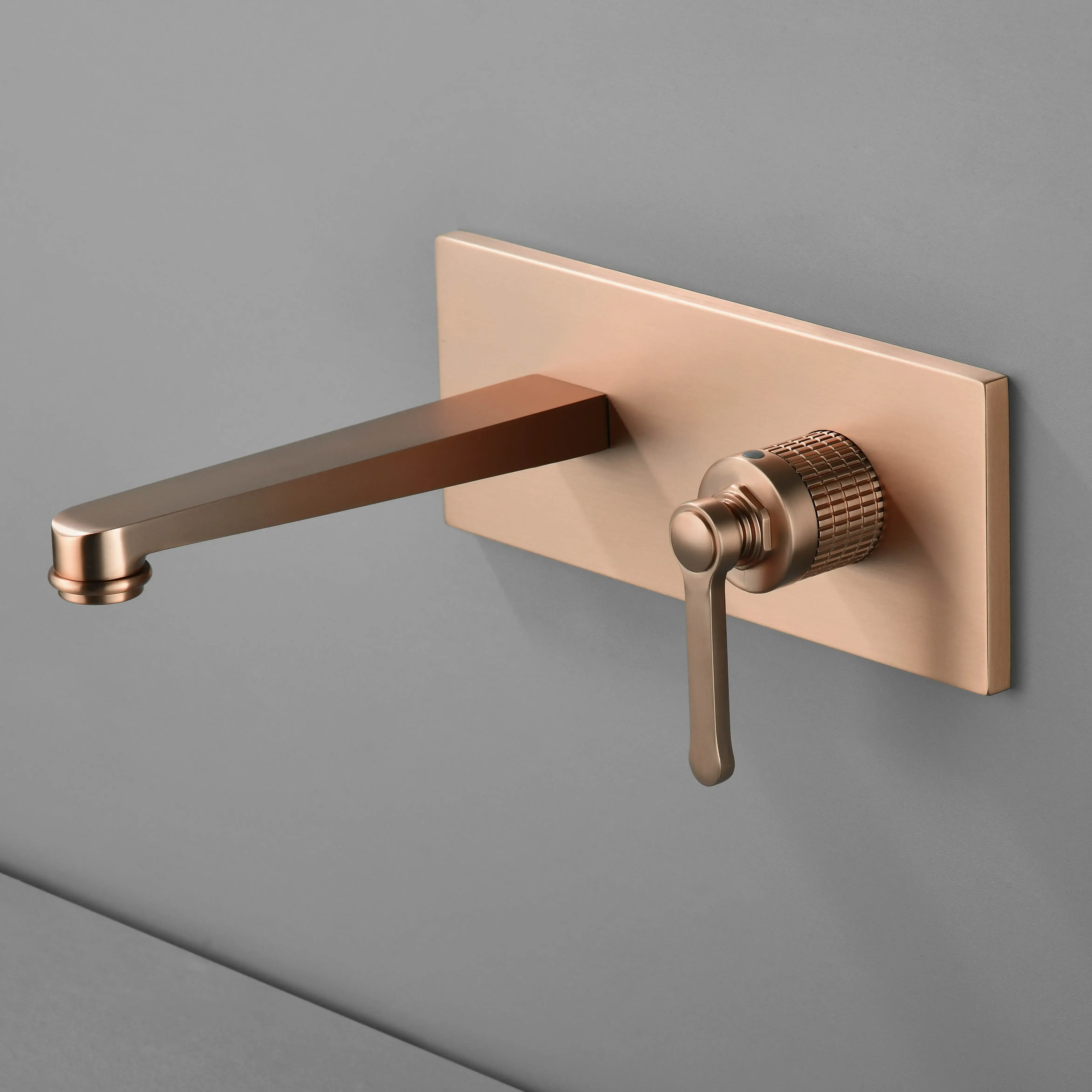 Mitigeur lavabo encastré mural cannelé César en doré rose brossé, design moderne avec poignée texturée et plaque rectangulaire, idéal pour une salle de bain élégante.