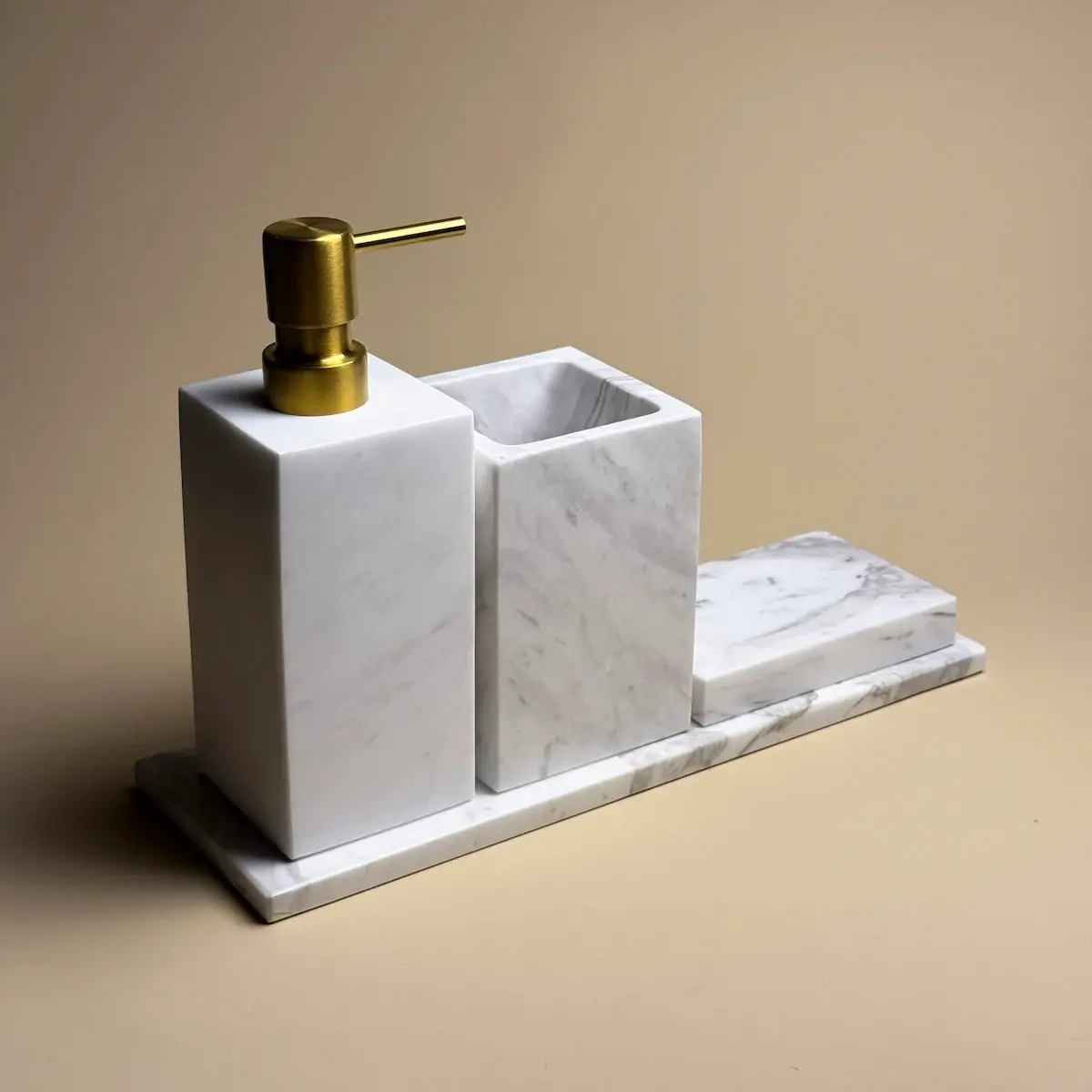 Vue de face de l'ensemble Yilstone en marbre blanc carré pour salle de bain, avec distributeur, pot et porte-savon.