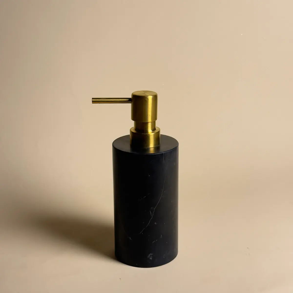 Distributeur de savon rond en marbre noir Nero Marquina avec pompe chromée, accessoire design Petra pour salle de bain moderne