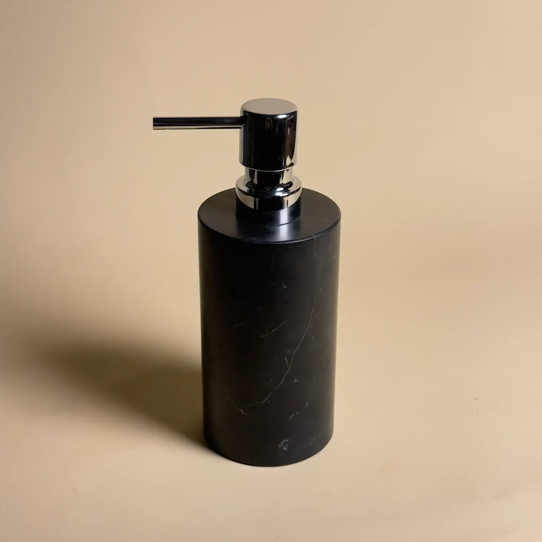 Distributeur de savon rond en marbre noir Nero Marquina avec pompe chromée, accessoire design Petra pour salle de bain moderne