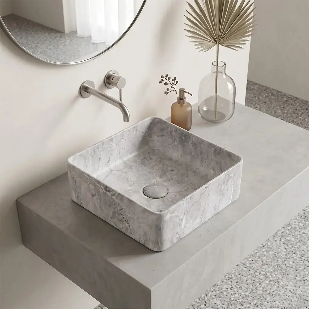 Vasque à poser carrée en céramique avec finition effet marbre gris clair, dotée d’une bonde centrale assortie.